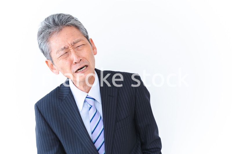 体調不良に苦しむ高齢のビジネスマン