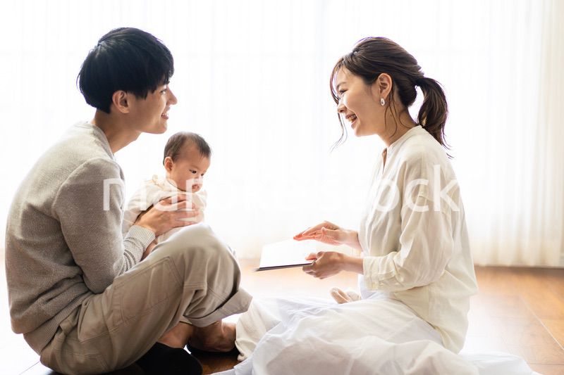 赤ちゃんに絵本の読み聞かせをするファミリー