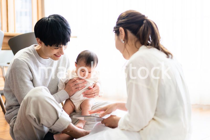 赤ちゃんに絵本の読み聞かせをするファミリー