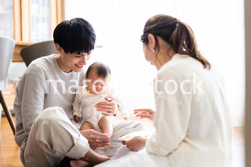 赤ちゃんに絵本の読み聞かせをするファミリー