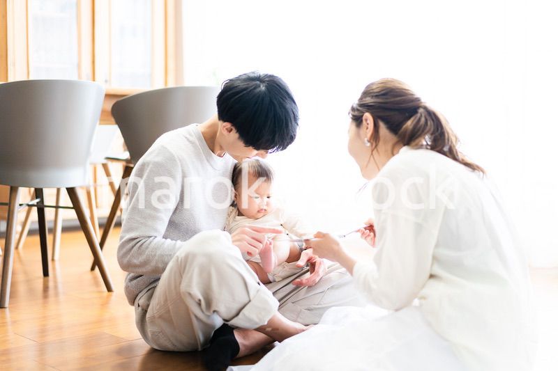 赤ちゃんに絵本の読み聞かせをするファミリー