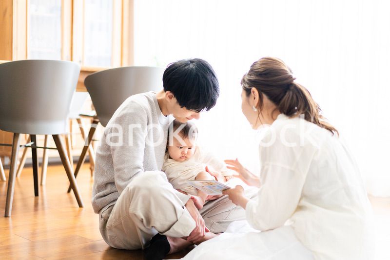 赤ちゃんに絵本の読み聞かせをするファミリー