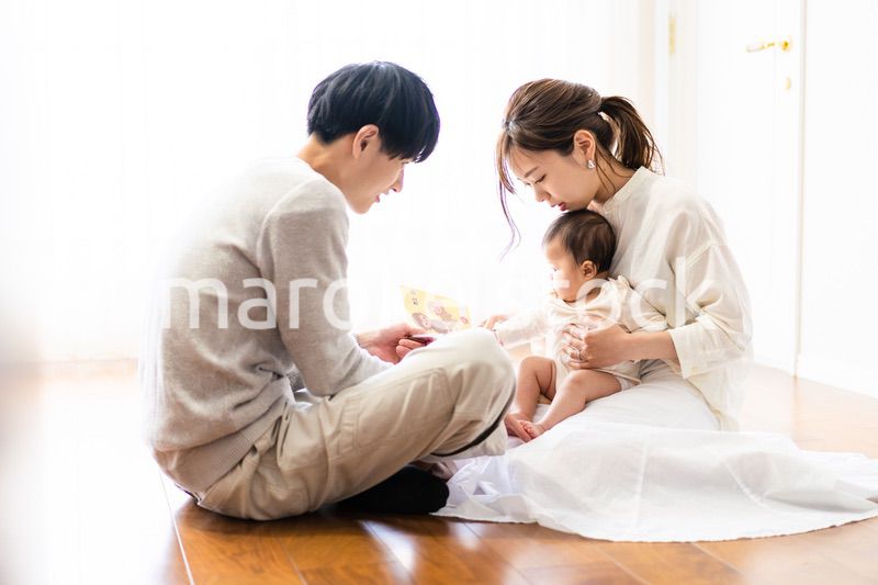 赤ちゃんに絵本の読み聞かせをするファミリー