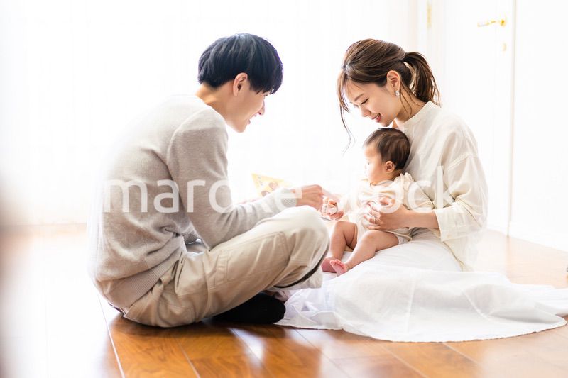 赤ちゃんに絵本の読み聞かせをするファミリー