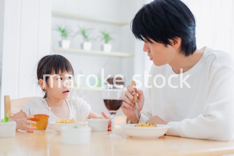 パパと一緒にご飯を食べる小さな女の子