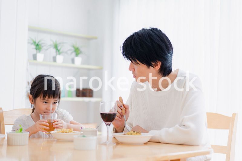 パパと一緒にご飯を食べる小さな女の子