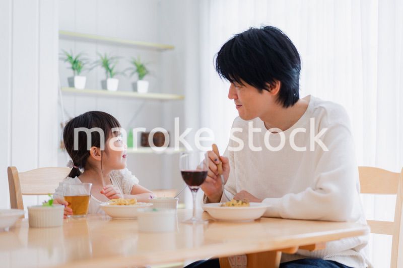 パパと一緒にご飯を食べる小さな女の子