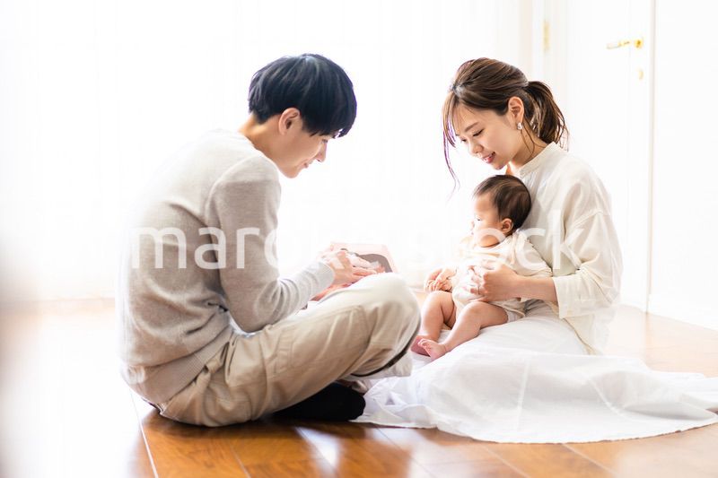 赤ちゃんに絵本の読み聞かせをするファミリー