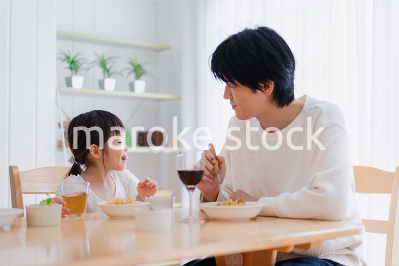 パパと一緒にご飯を食べる小さな女の子
