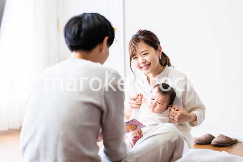 赤ちゃんに絵本の読み聞かせをするファミリー