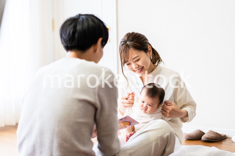 赤ちゃんに絵本の読み聞かせをするファミリー