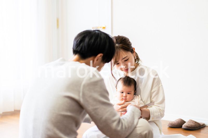 赤ちゃんに絵本の読み聞かせをするファミリー