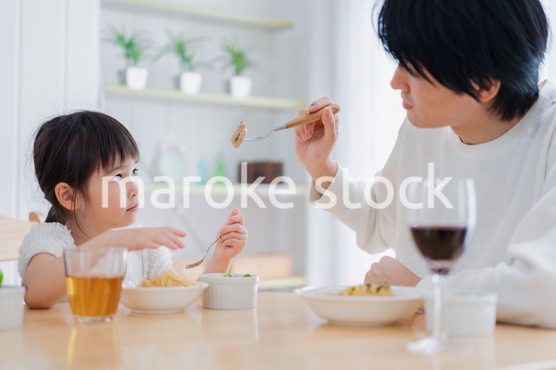 パパと一緒にご飯を食べる小さな女の子