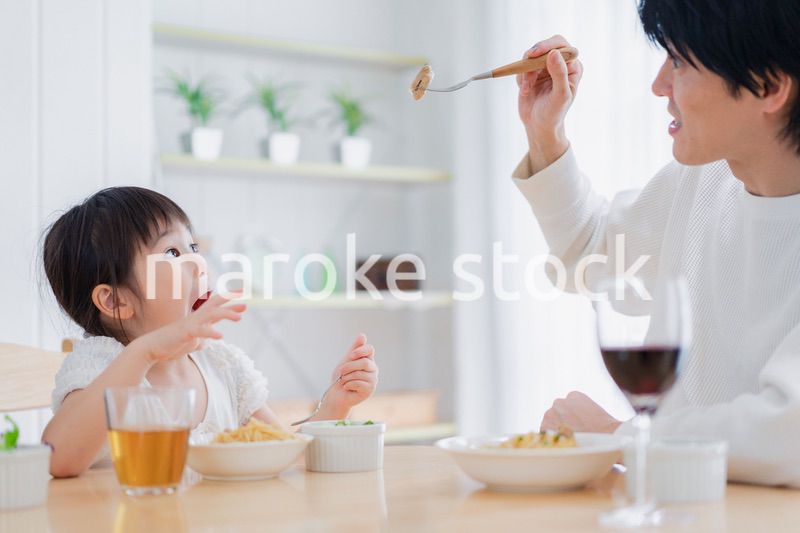 パパと一緒にご飯を食べる小さな女の子