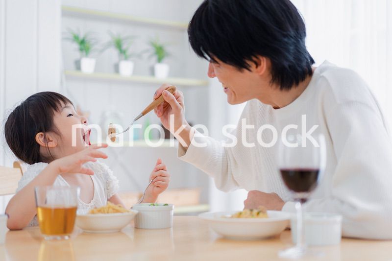 パパと一緒にご飯を食べる小さな女の子