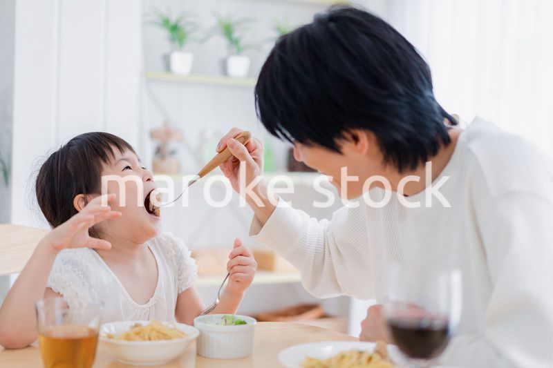 パパと一緒にご飯を食べる小さな女の子