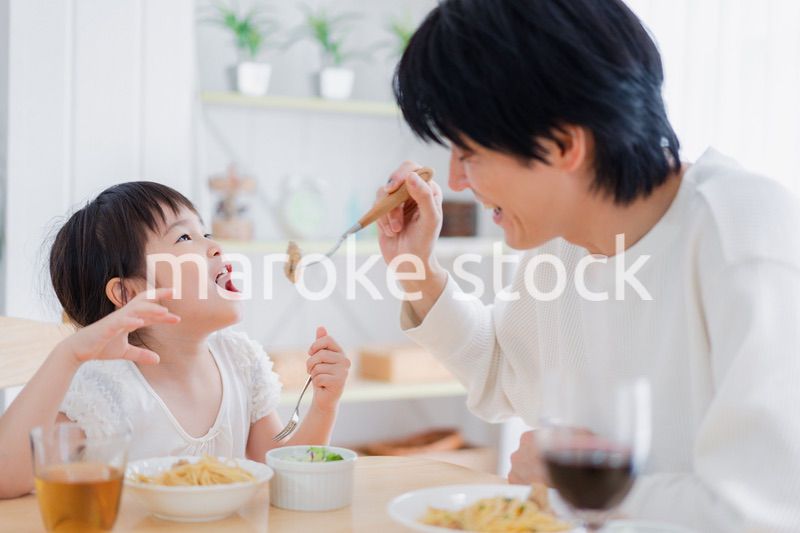 パパと一緒にご飯を食べる小さな女の子