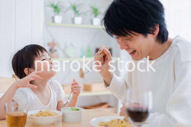 パパと一緒にご飯を食べる小さな女の子