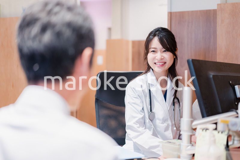 クリニックで男性患者の診察をする女性医師