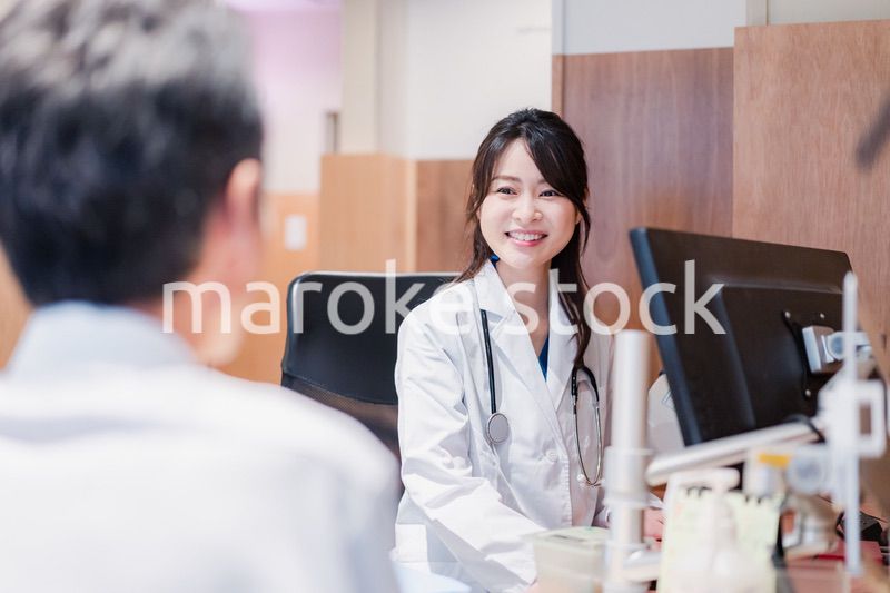 クリニックで男性患者の診察をする女性医師