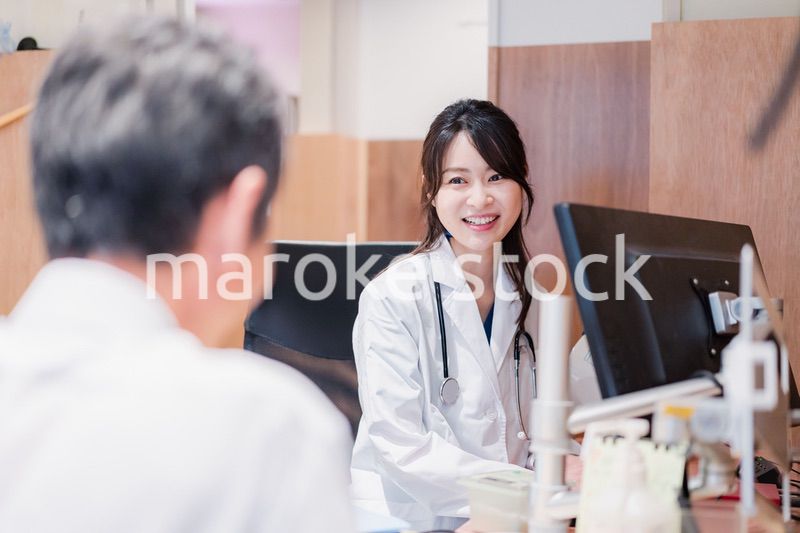 クリニックで男性患者の診察をする女性医師