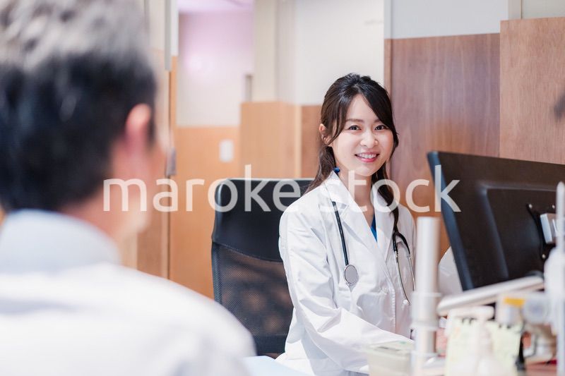クリニックで男性患者の診察をする女性医師