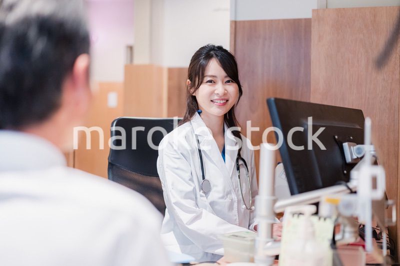 クリニックで男性患者の診察をする女性医師