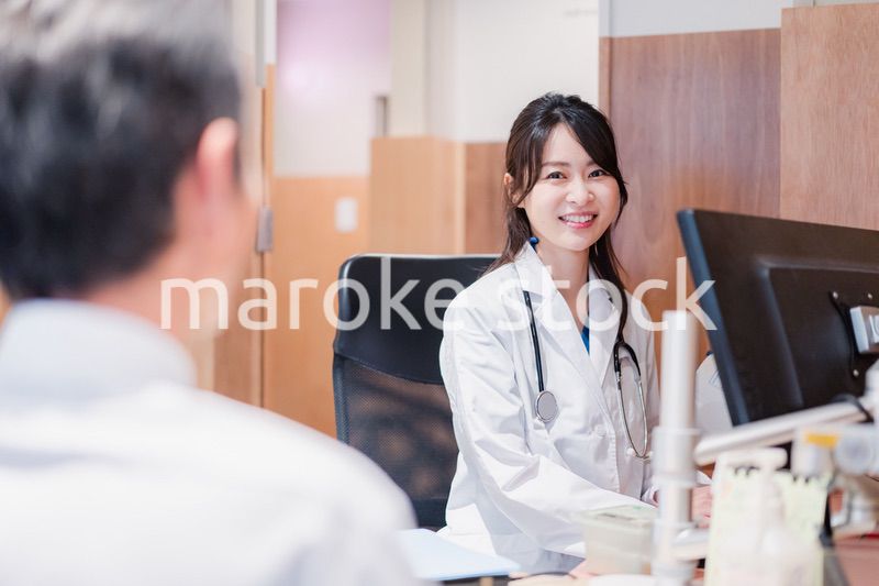 クリニックで男性患者の診察をする女性医師