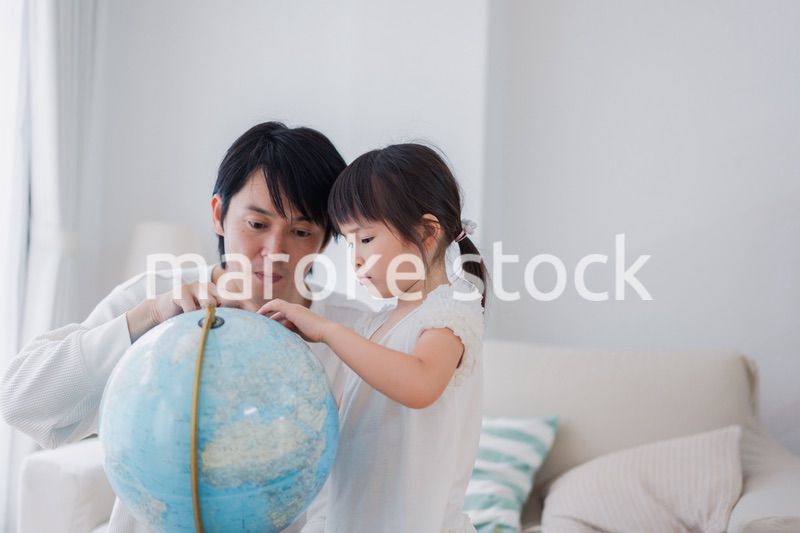 パパと地球儀を使って勉強する家族