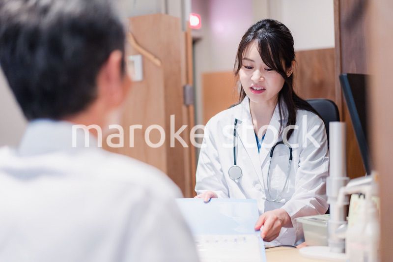 クリニックで男性患者の診察をする女性医師