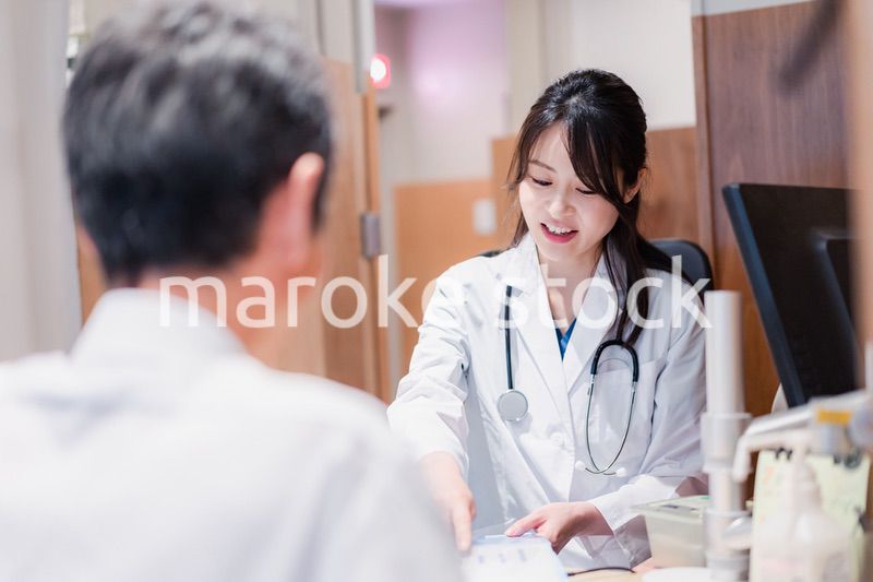 クリニックで男性患者の診察をする女性医師
