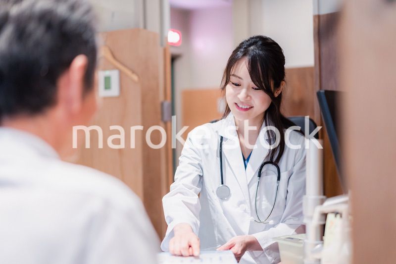 クリニックで男性患者の診察をする女性医師