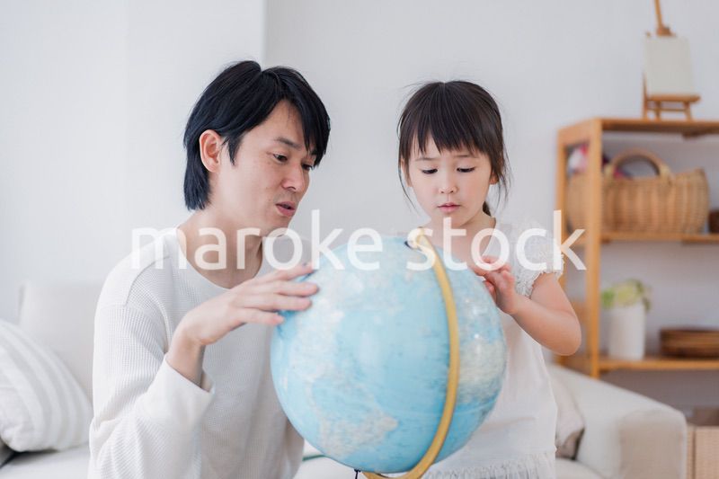 パパと地球儀を使って勉強する家族