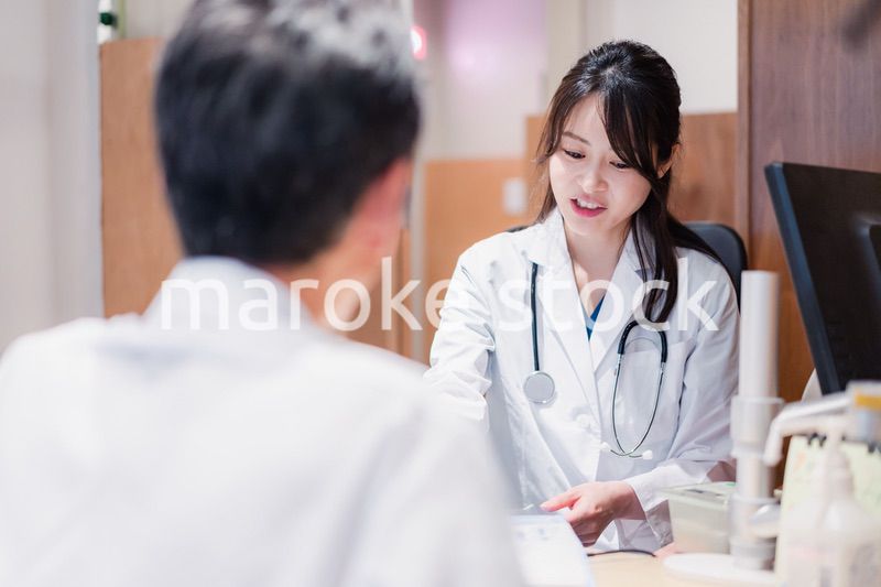 クリニックで男性患者の診察をする女性医師