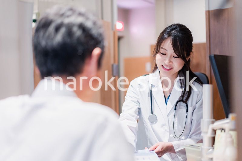クリニックで男性患者の診察をする女性医師