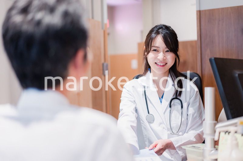 クリニックで男性患者の診察をする女性医師