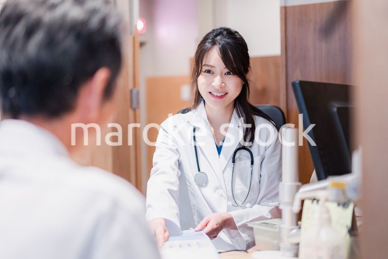 クリニックで男性患者の診察をする女性医師