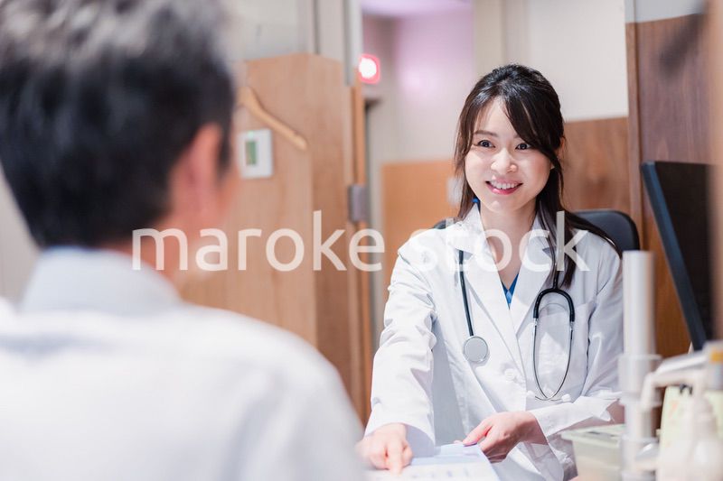 クリニックで男性患者の診察をする女性医師