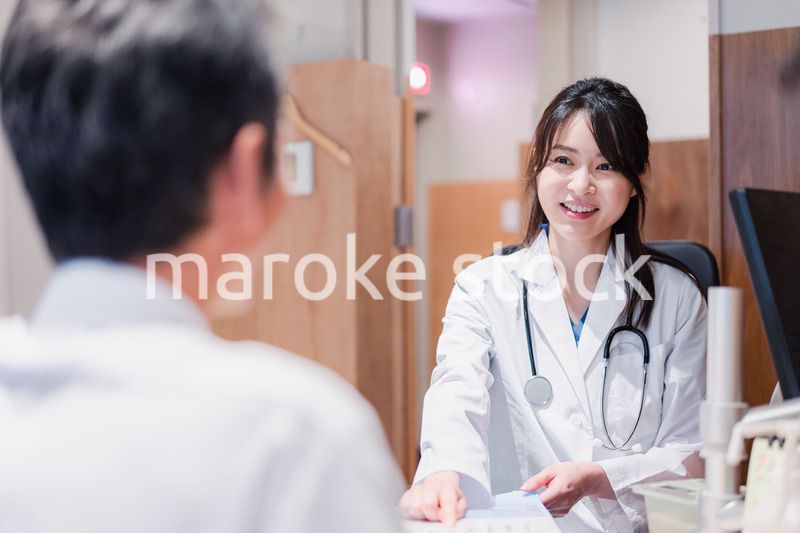 クリニックで男性患者の診察をする女性医師