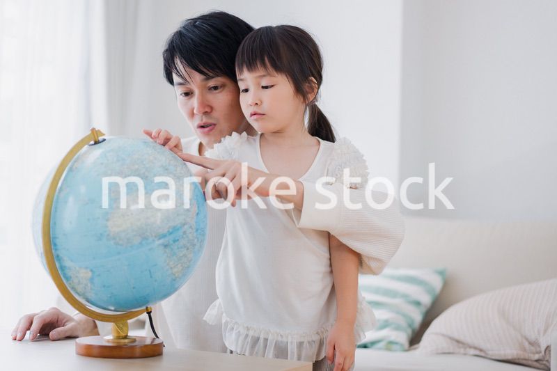 パパと地球儀を使って勉強する家族