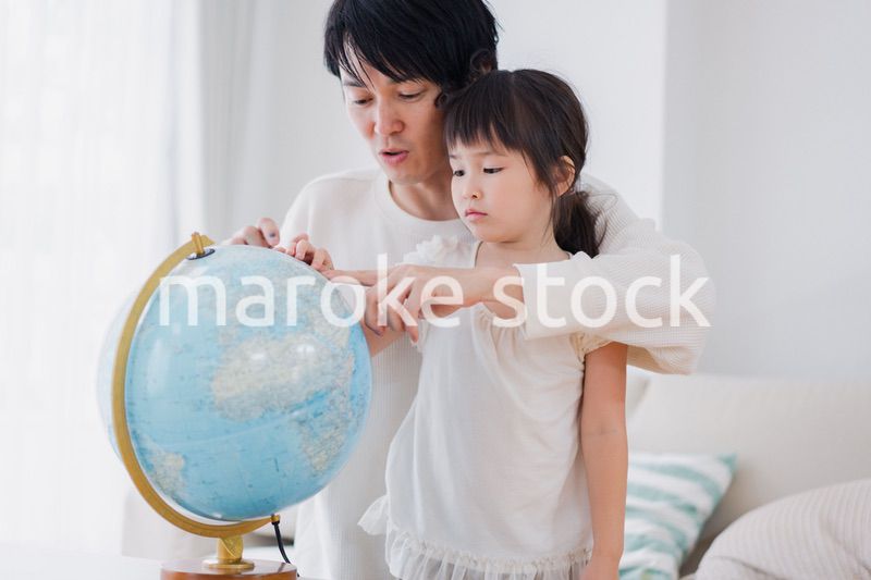 パパと地球儀を使って勉強する家族