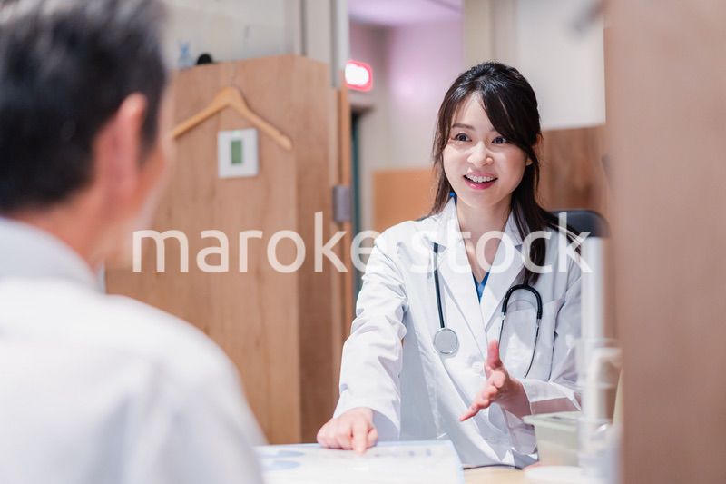 クリニックで男性患者の診察をする女性医師