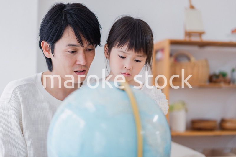 パパと地球儀を使って勉強する家族