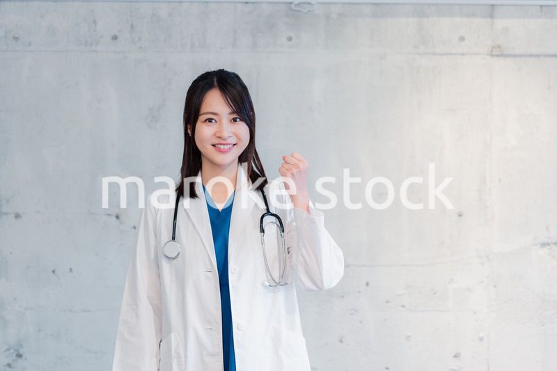 笑顔でグッドサインをする女性ドクター