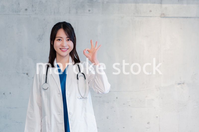 笑顔でグッドサインをする女性ドクター