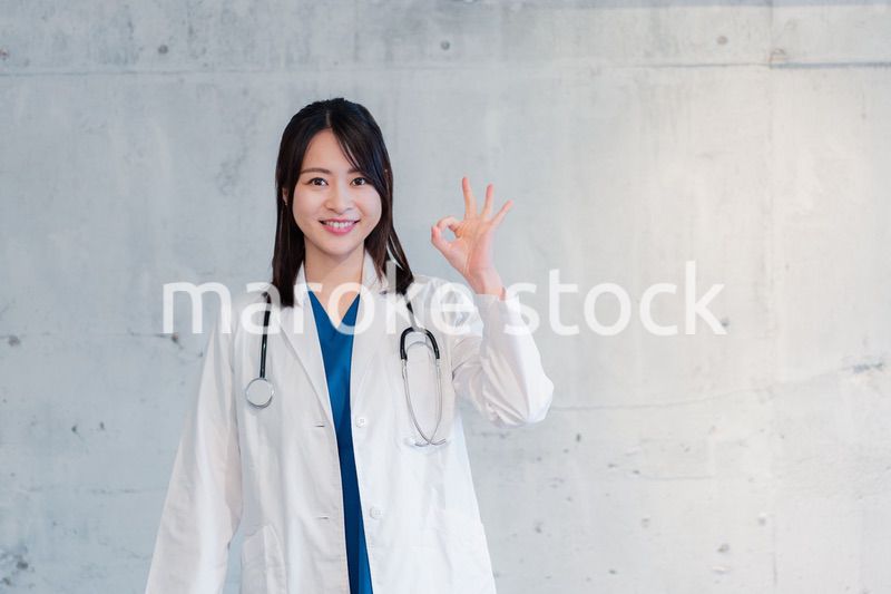 笑顔でグッドサインをする女性ドクター