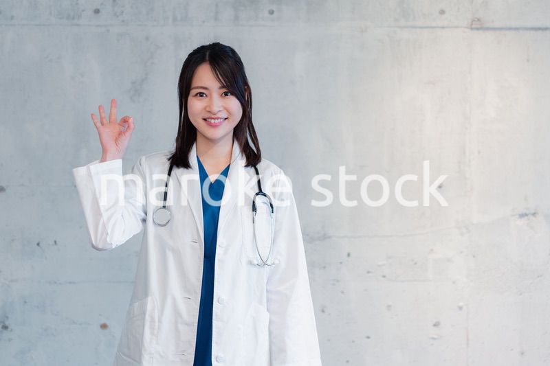 笑顔でグッドサインをする女性ドクター