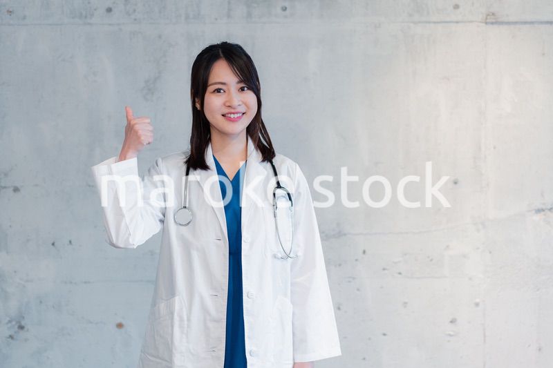 笑顔でグッドサインをする女性ドクター