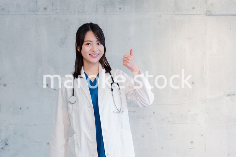笑顔でグッドサインをする女性ドクター