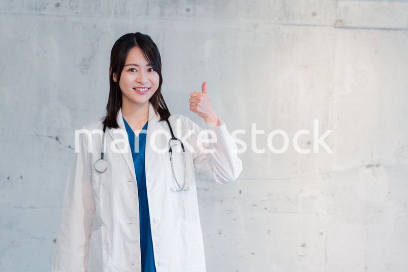 笑顔でグッドサインをする女性ドクター